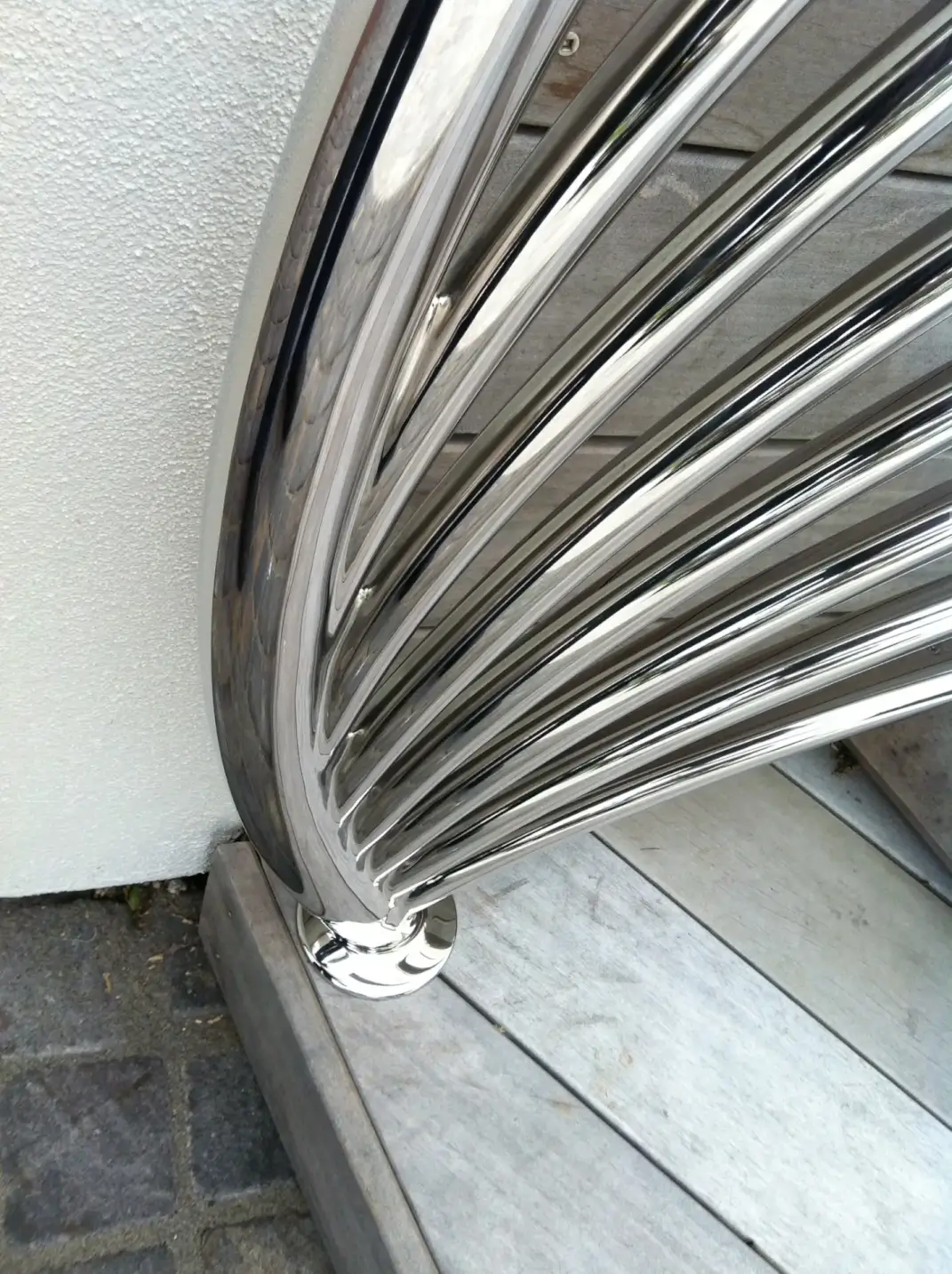 Close-up curved stainless steel handrail base detail