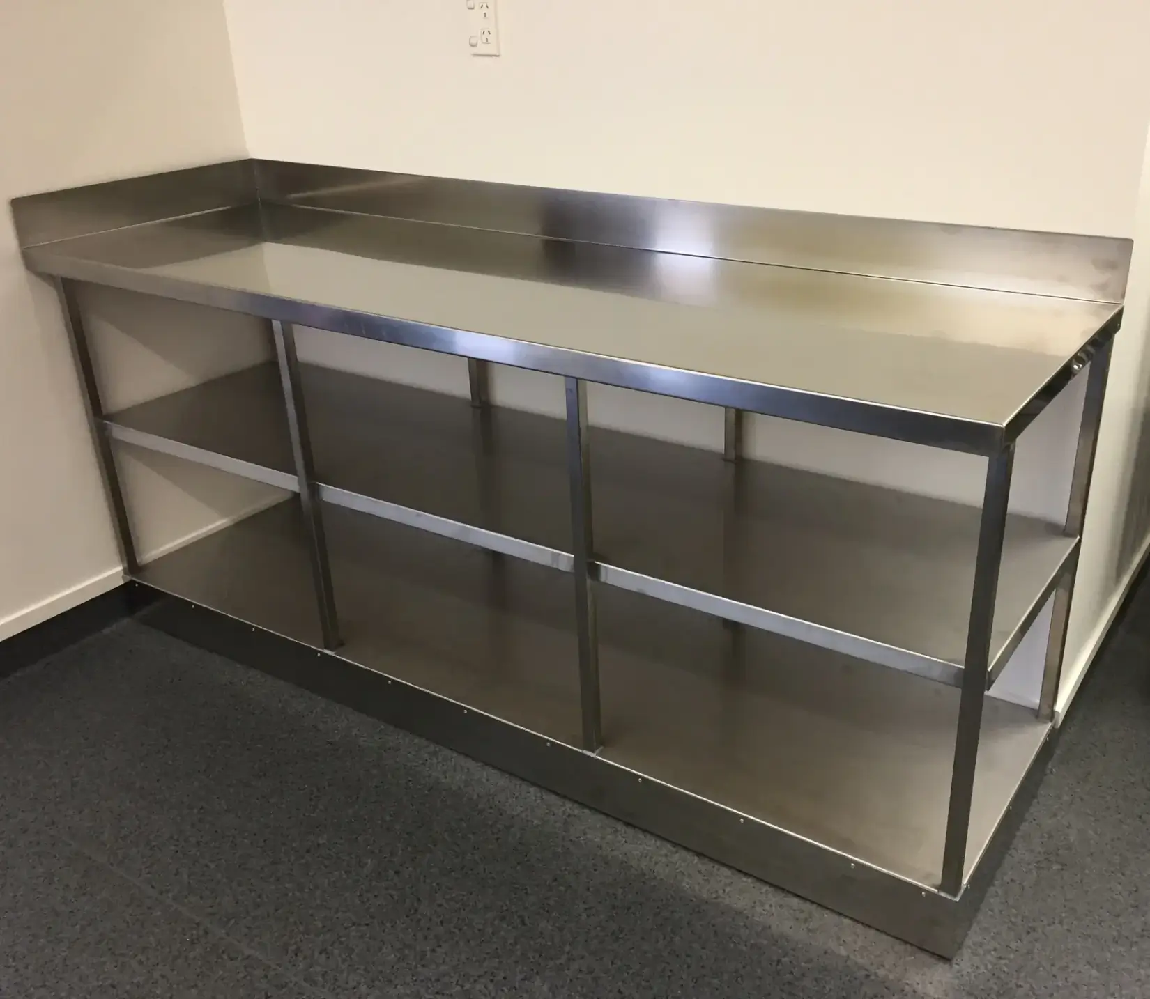 Stainless steel commercial kitchen benchtop with storage shelves